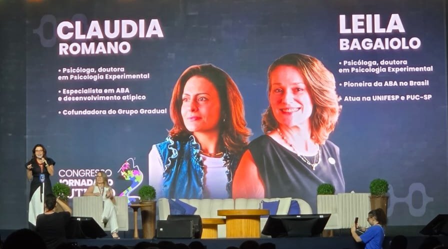 Telão do Congresso Jornada do Autismo 2026 exibindo as fotos e currículos de Cláudia Romano e Leila Bagaiolo, palestrantes da sessão sobre ABA no Brasil