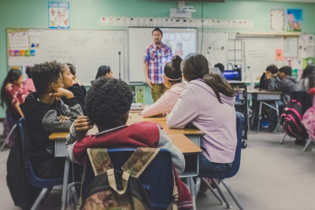 Sala de aula comum: professor e estudantes — capa sobre PEI autismo, PAEE e obrigações da escola